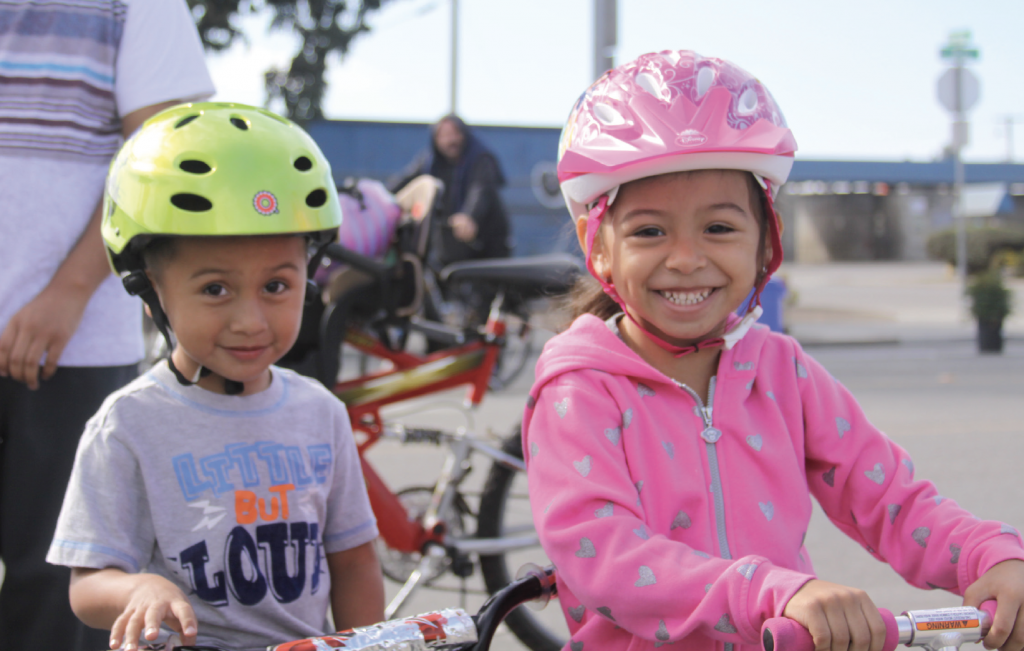 kids smiling and wearing bike helmets