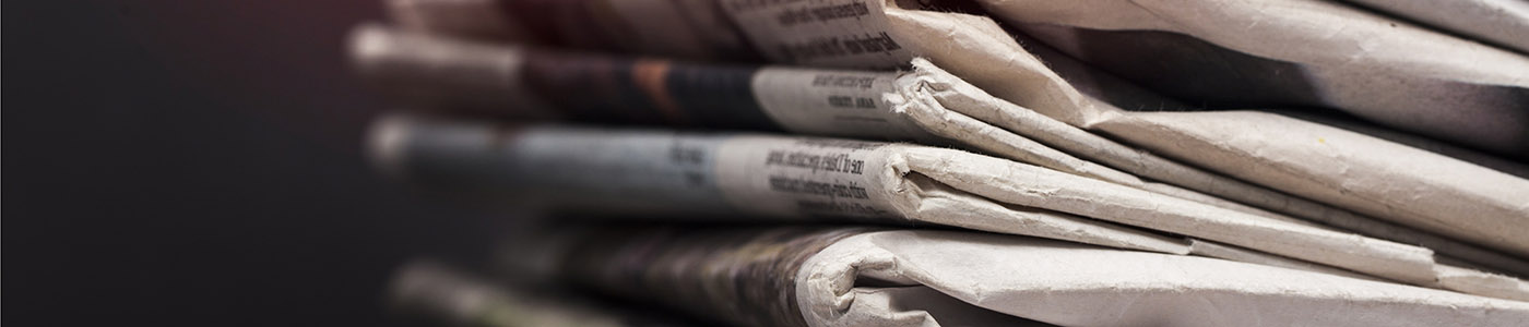 Stack of newspapers against a dark background